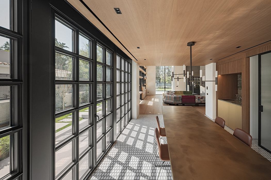 Expansive windows, wooden beamed ceiling, and patterned tile flooring in modern interior.