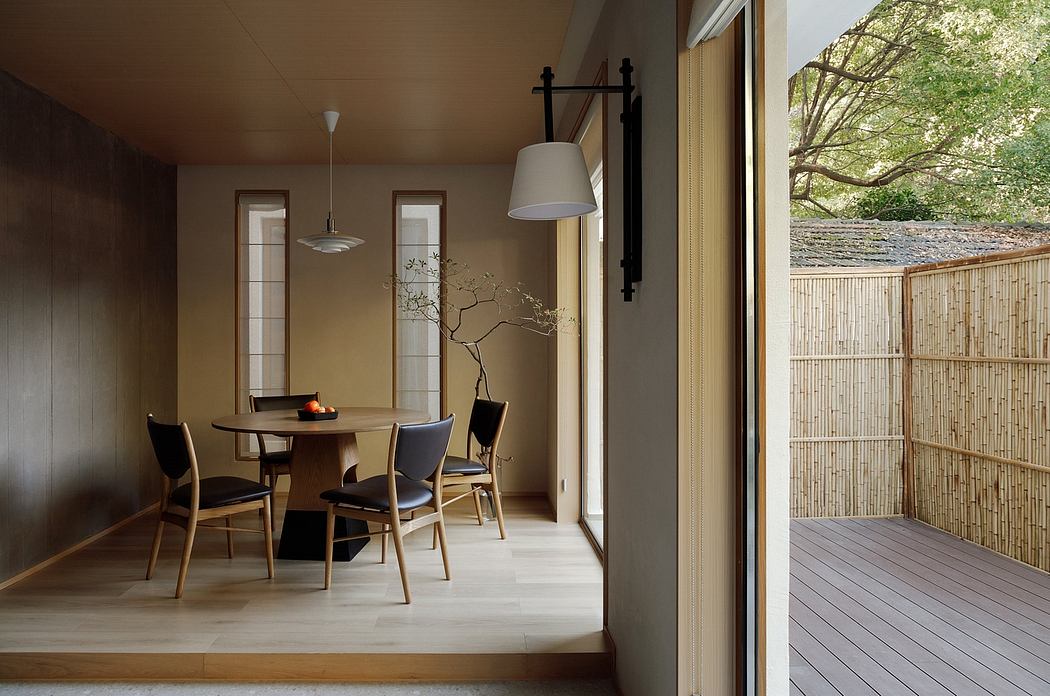 Warm, minimal dining area with wooden furniture, lighting, and sliding glass door to deck.