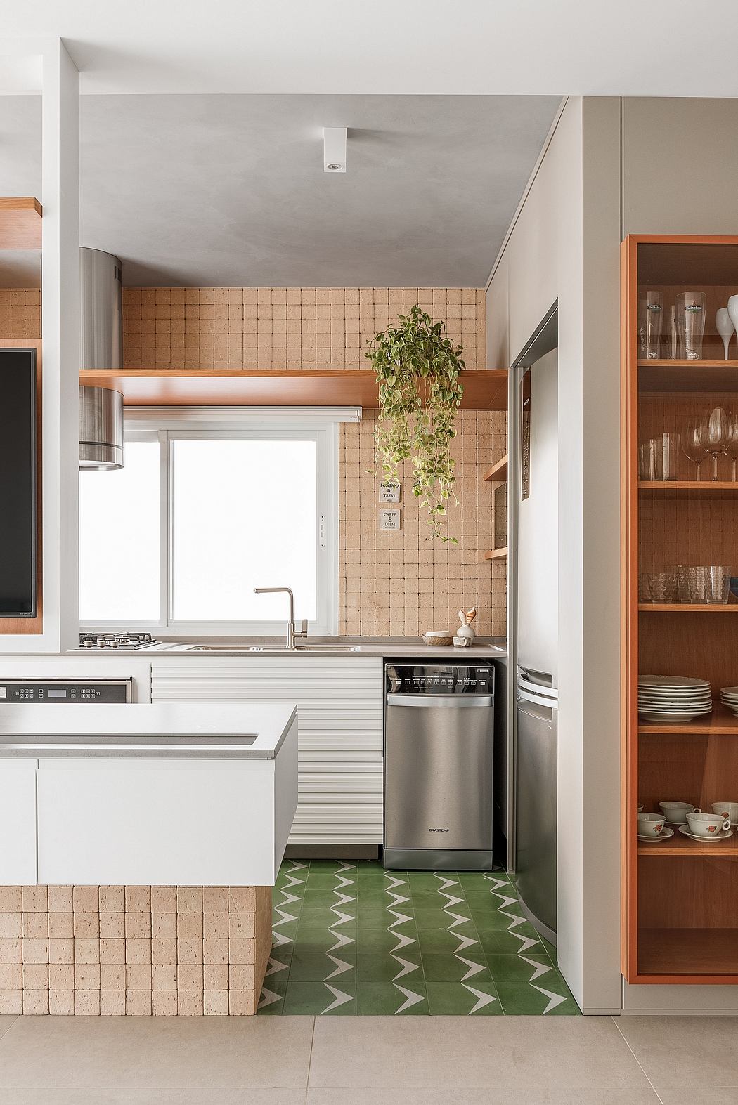 Sleek modern kitchen with natural tile, wood accents, and a hanging plant feature.