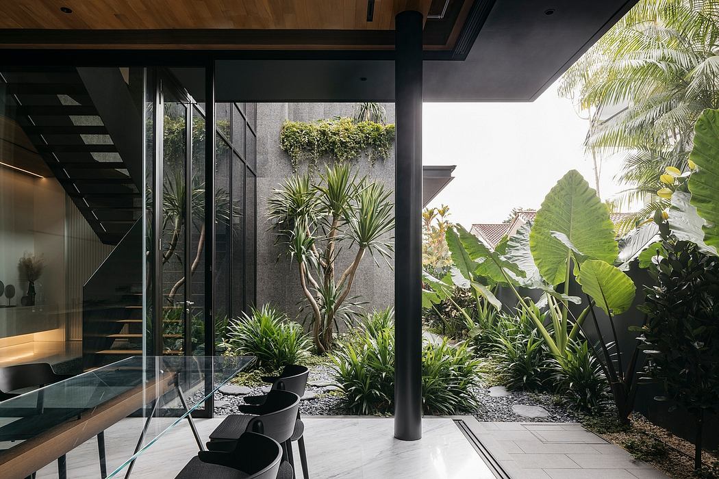 Serene indoor-outdoor space with glass walls, lush greenery, and minimalist decor.