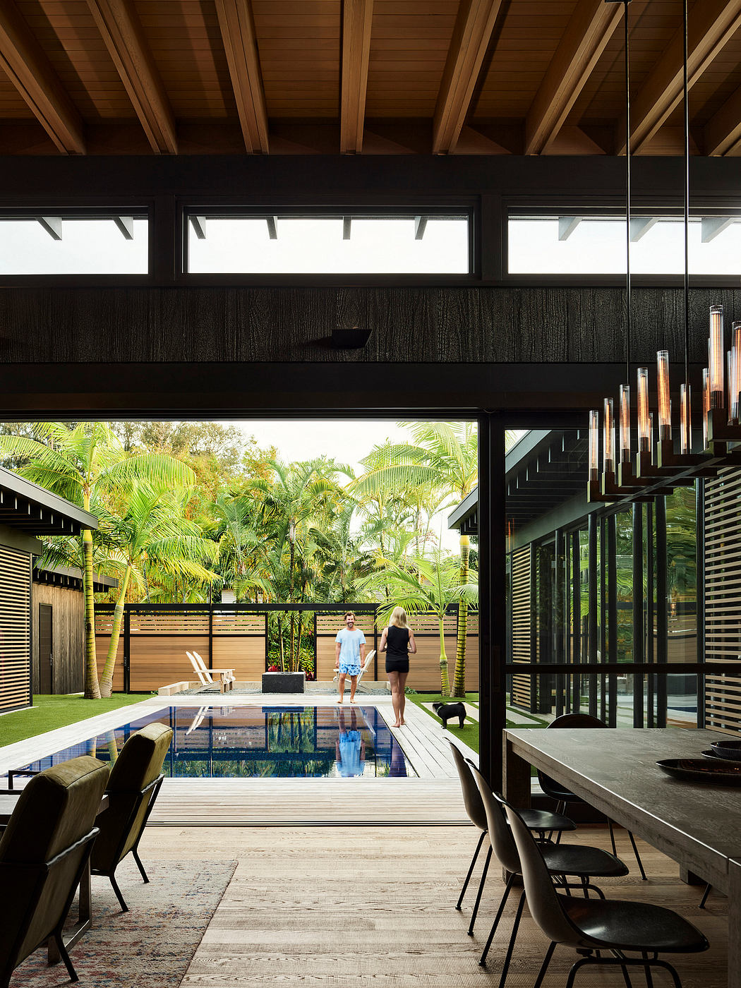 Sleek modern architecture with lush tropical foliage, welcoming pool, and minimalist furnishings.