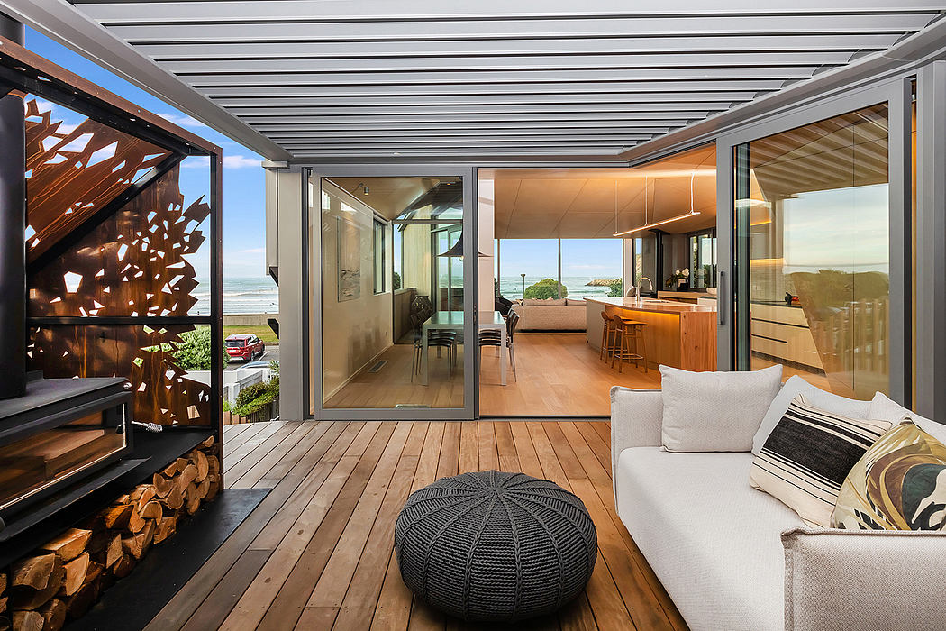 Sleek modern beach house design with wood beams, large windows, and cozy lounge area.