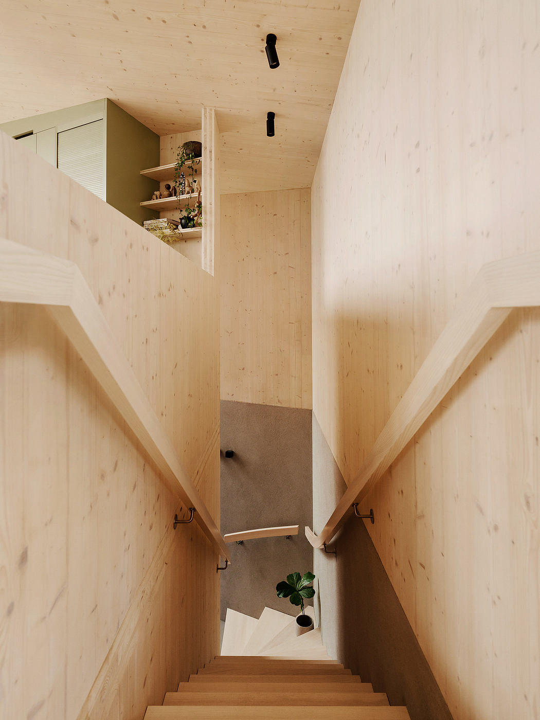 Wooden staircase leading to bright, minimalist upper level with shelving and decor.