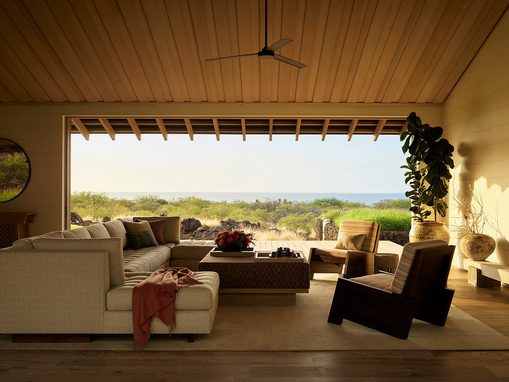 A cozy living room with a wooden ceiling, large windows, and a scenic nature view.