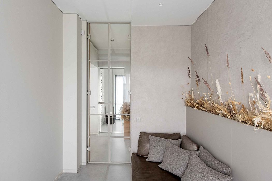 Minimalist interior with glass sliding doors, neutral color palette, and decorative dried flowers.