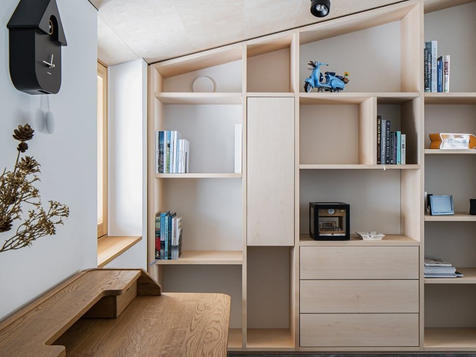 Modern built-in shelving and storage with wooden accents in a minimalist space.