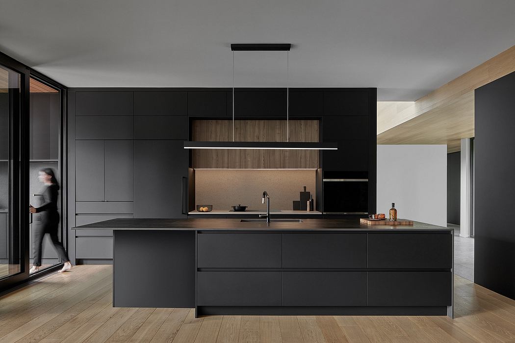 Modern kitchen with sleek black cabinetry, minimalist lighting, and wooden accents.