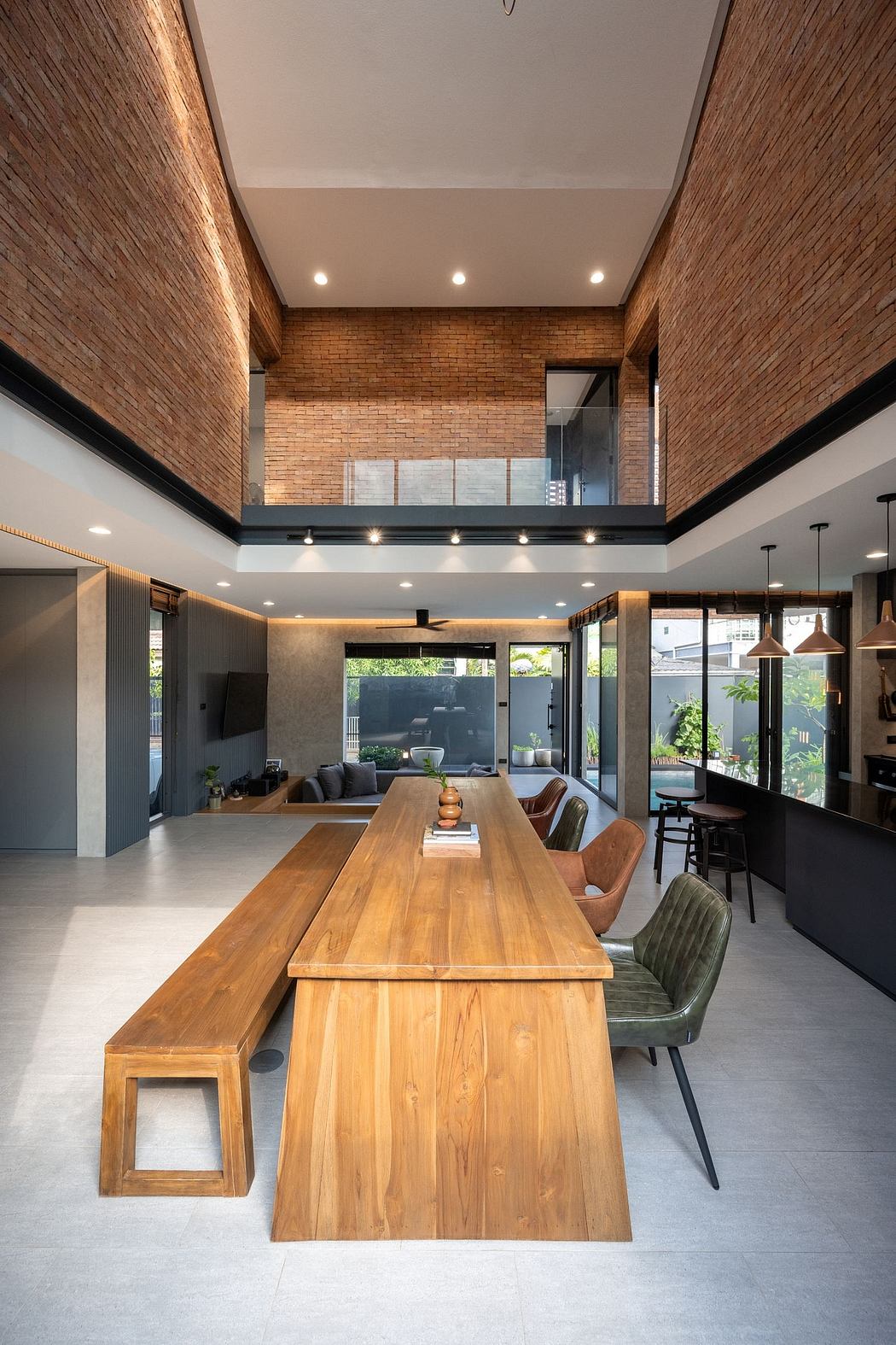 Warm, inviting open-plan interior with exposed brick walls, wooden dining table, and cozy seating area.
