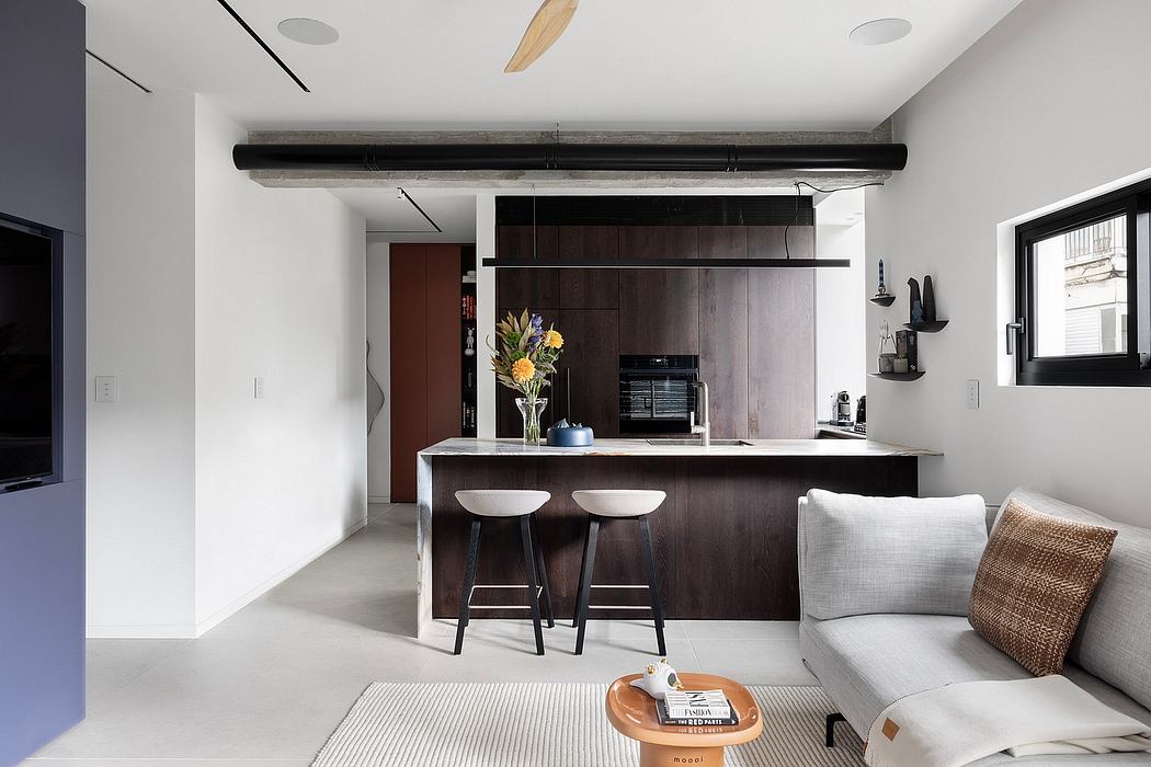 Modern, minimalist kitchen and living room with clean lines, dark wood cabinetry, and contrasting textures.