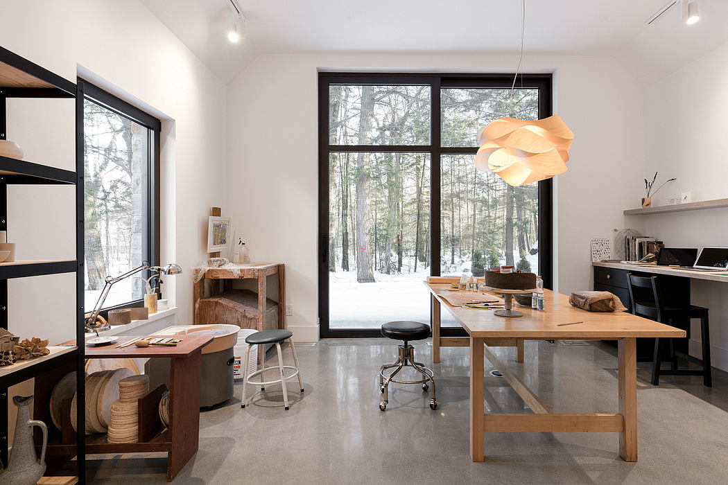 Spacious, minimalist interior with large windows overlooking forested landscape.