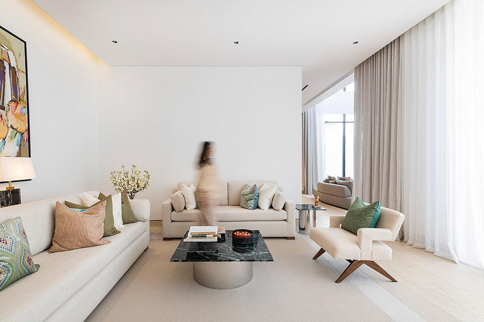 Minimalist living room with neutral tones, modern furniture, and artwork.