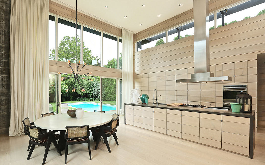 Spacious open-plan kitchen and dining area with modern, minimalist design and large windows.