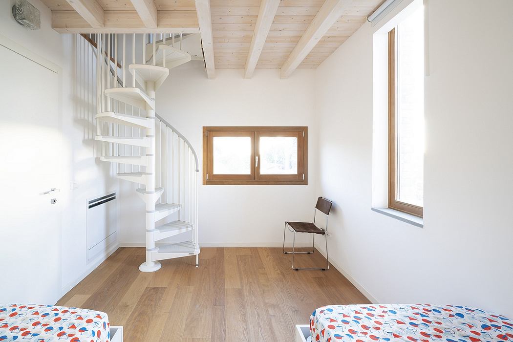 Minimalist, bright room with a spiral staircase, wooden beams, and a window overlooking the outdoors.