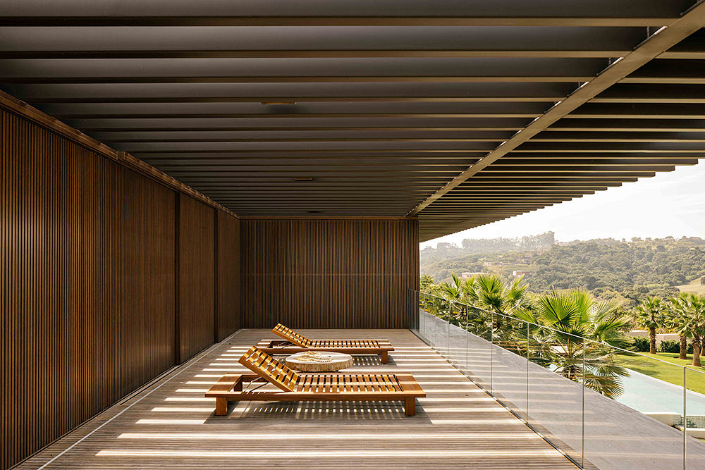Rustic wooden beams frame an open-air patio with lush garden views.