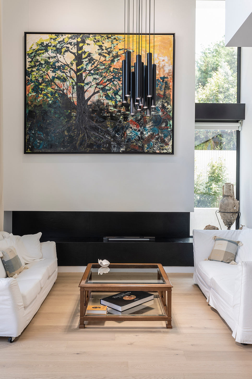 A vibrant abstract painting on the wall, flanked by modern lighting fixtures, sets the tone for this contemporary living space.