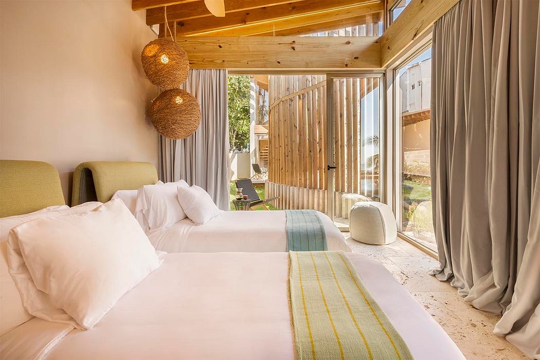 Cozy bedroom with wooden beams, warm lighting, and sliding glass doors opening to the outdoors.