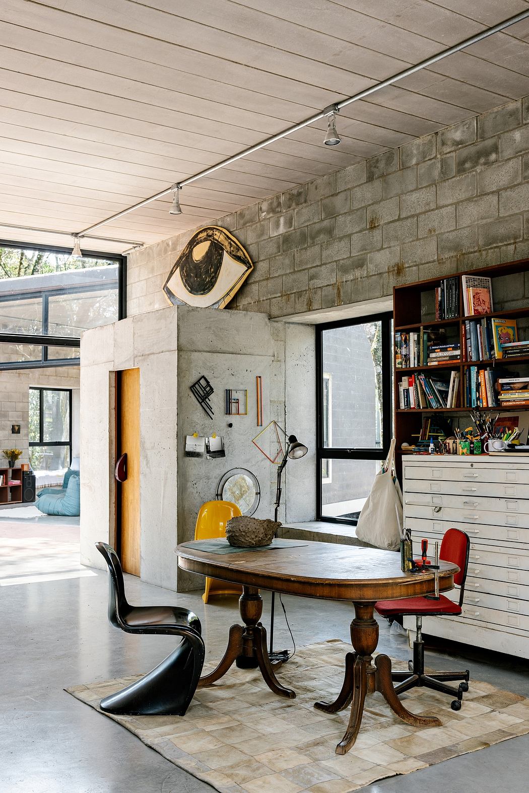 Eclectic home office with exposed brick walls, wood furniture, and diverse decor elements.