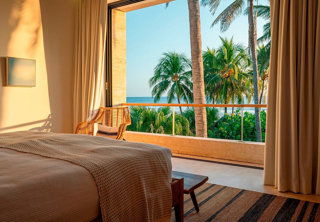 A spacious tropical-style bedroom with large windows overlooking lush palm trees and the ocean.