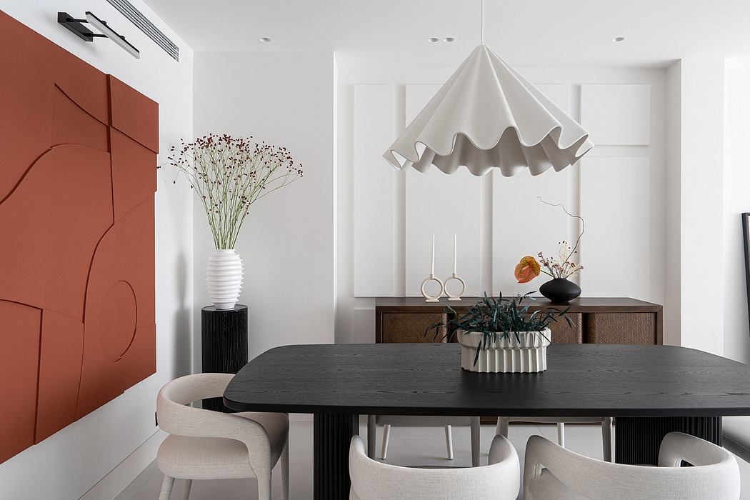 A modern, minimalist dining room featuring a sleek black table, sculptural lighting, and architectural decor.