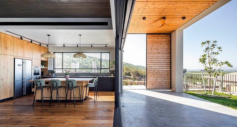 Modern open-plan kitchen and dining area with wood accents, panoramic mountain views.