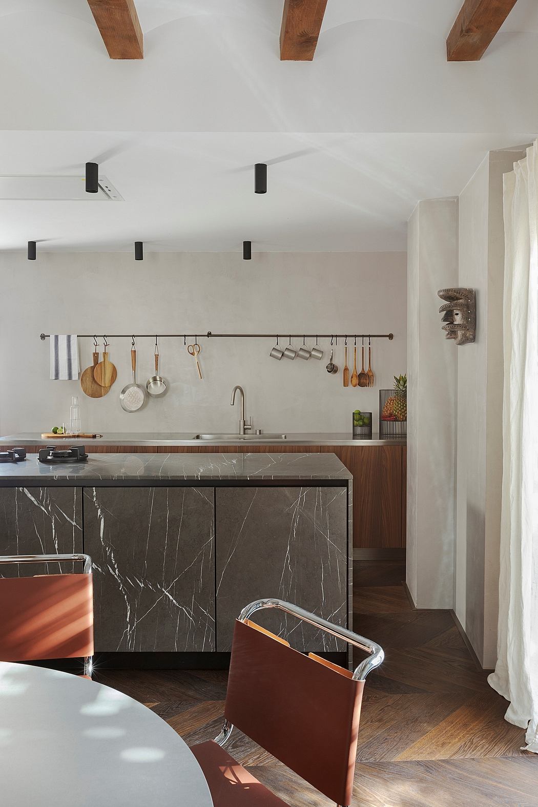 Minimalist kitchen design with wooden beams, dark marble countertops, and sleek, modern fixtures.