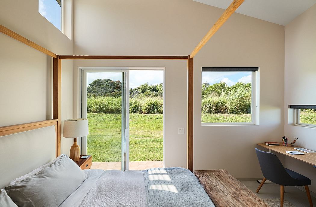 Spacious bedroom with large windows overlooking a verdant landscape, showcasing clean lines and natural materials.