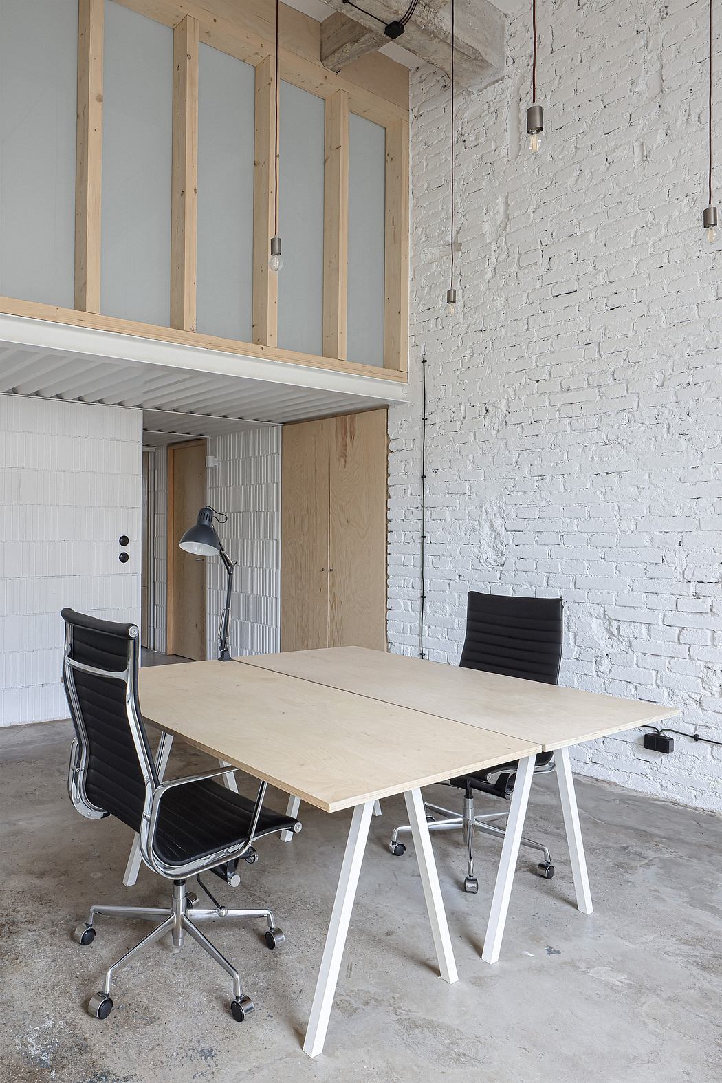 Modern office space with exposed brick walls, wood and metal accents, and minimalist furniture.