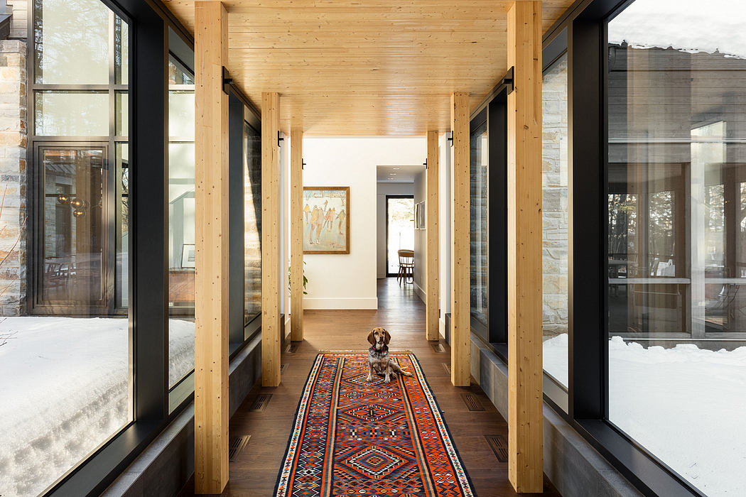 Modern wooden interior with expansive windows and a patterned area rug.