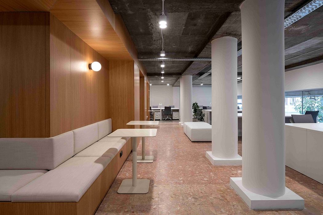 Spacious open-plan office with exposed concrete ceiling, wooden walls, and cork flooring.