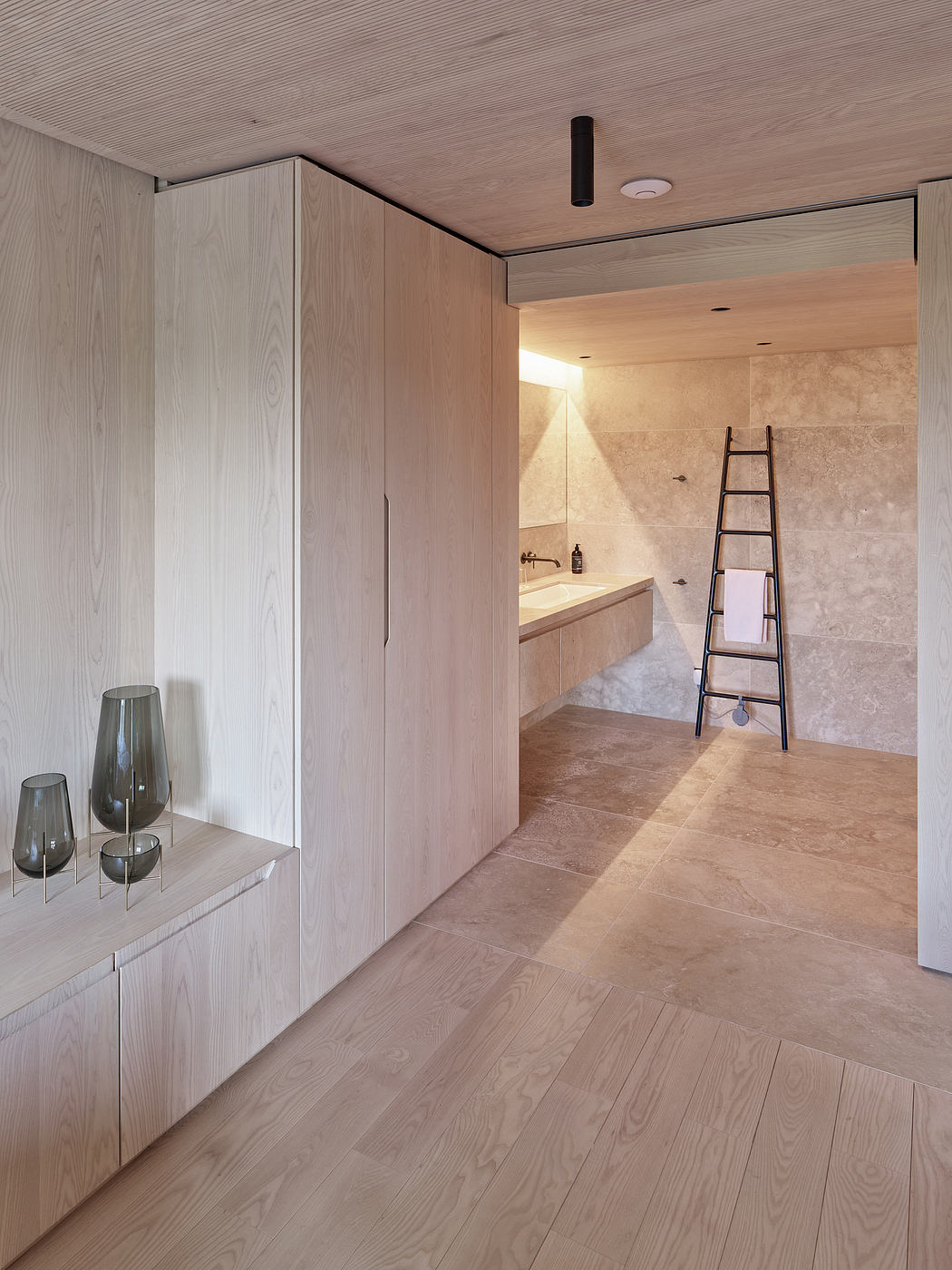 Minimalist bathroom with wood-paneled walls, built-in vanity, and tiled flooring.