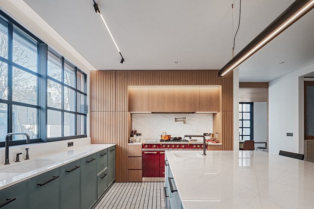 A modern, sleek kitchen with clean lines, wood paneling, and a striking red stove.