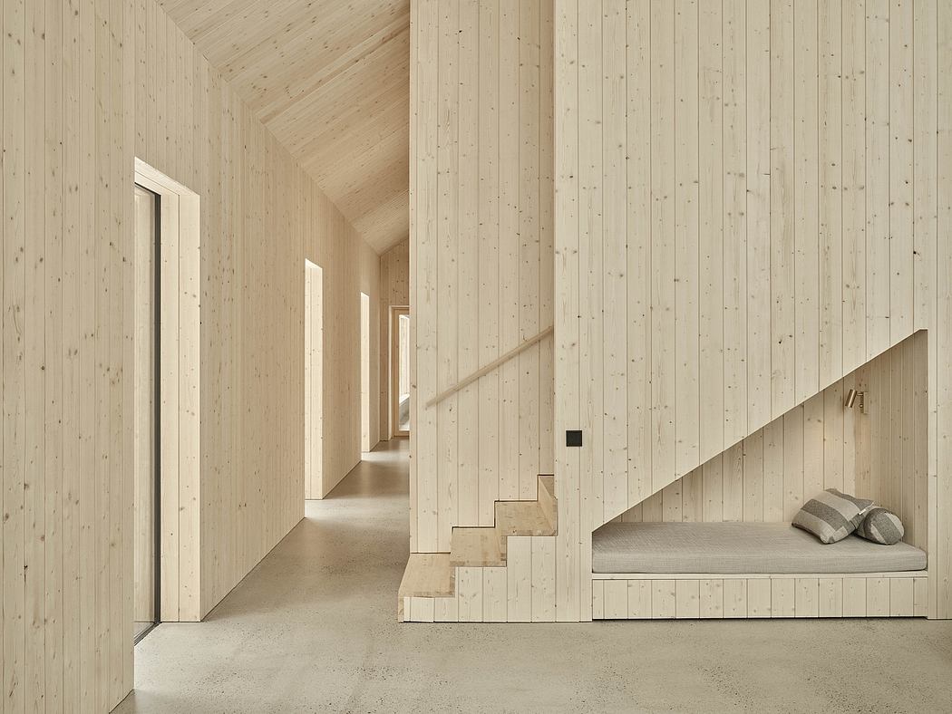Wooden paneled hallway with built-in bench seating and minimal, modern architectural design.