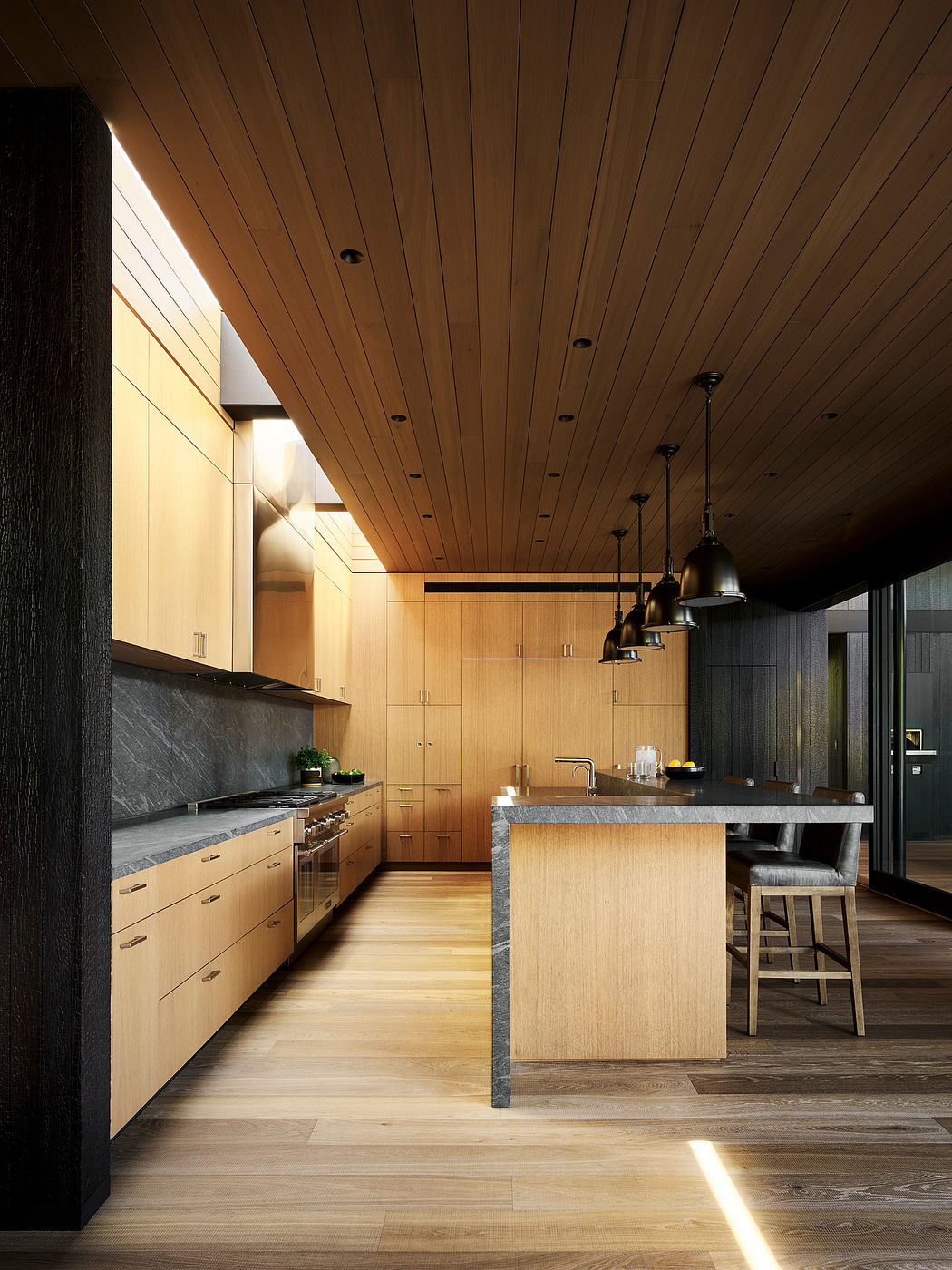 A modern kitchen featuring a wooden ceiling, stone countertops, and pendant lights.