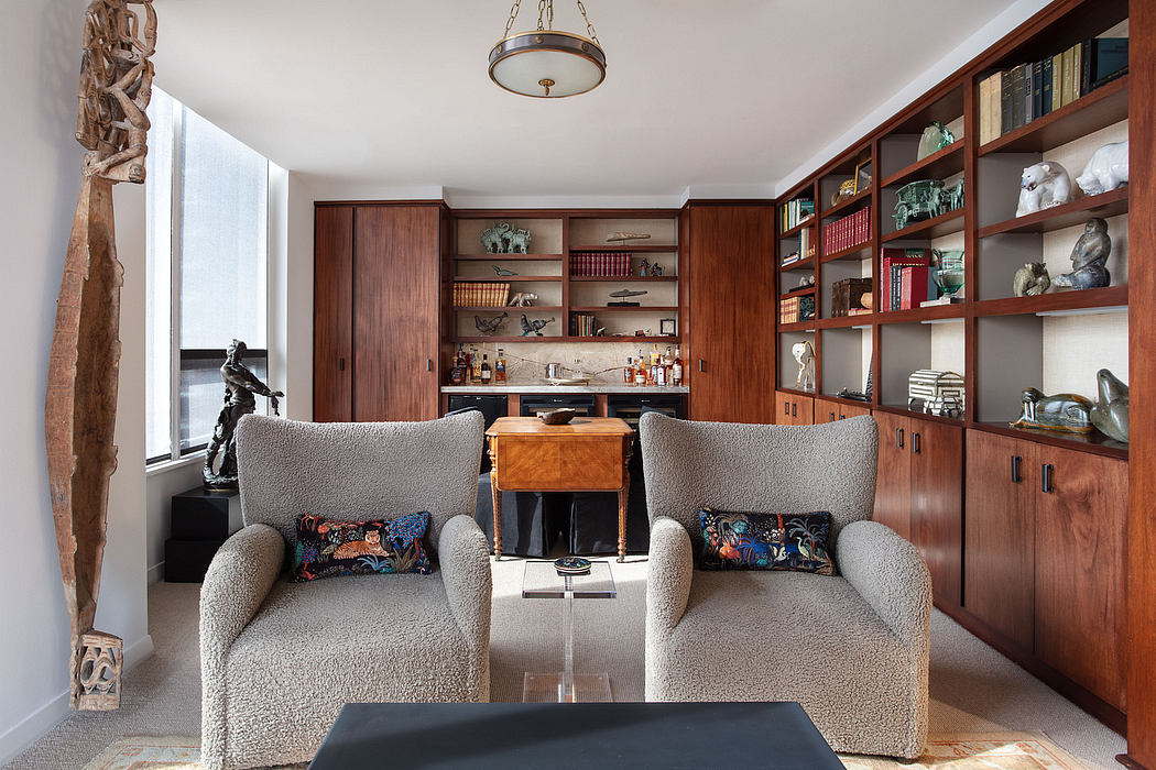 Warm-toned, midcentury-inspired interior with wooden built-in shelving and cozy armchairs.