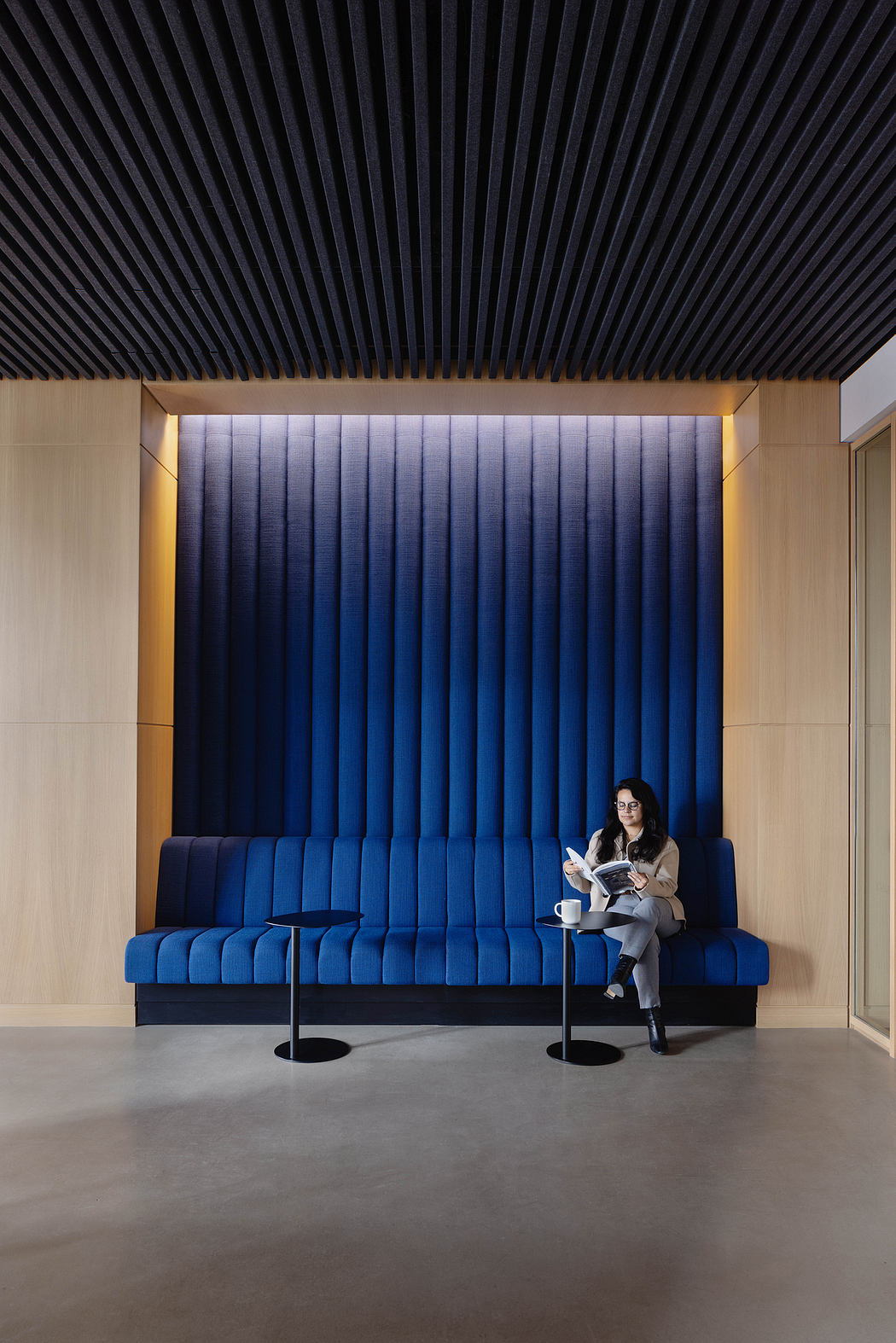 Striking modern interior with blue-toned paneled walls and a comfortable seating area.