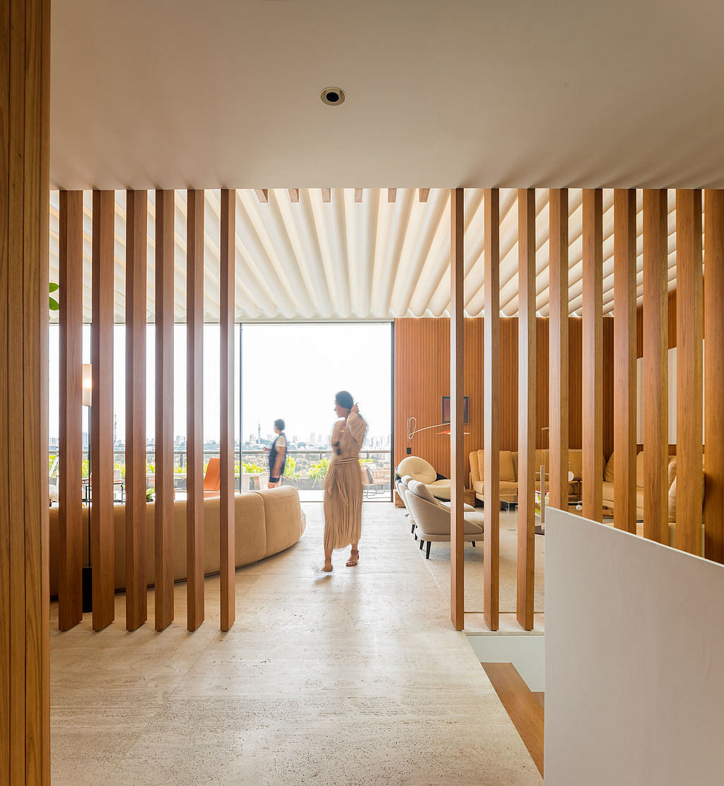 Minimalist interior design with wooden slat walls, cozy seating, and expansive city view.