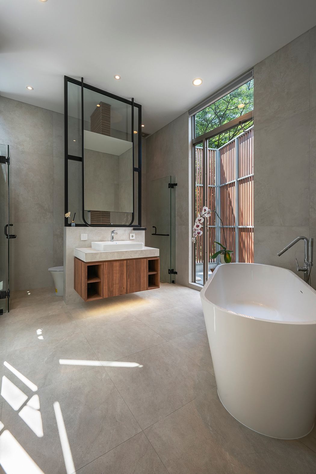 Spacious modern bathroom with a freestanding tub and wooden vanity cabinet.
