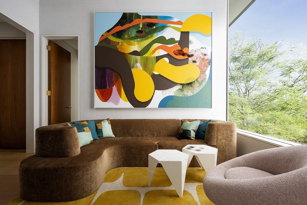 A modern living room with a large abstract artwork, curved couch, and geometric coffee table.