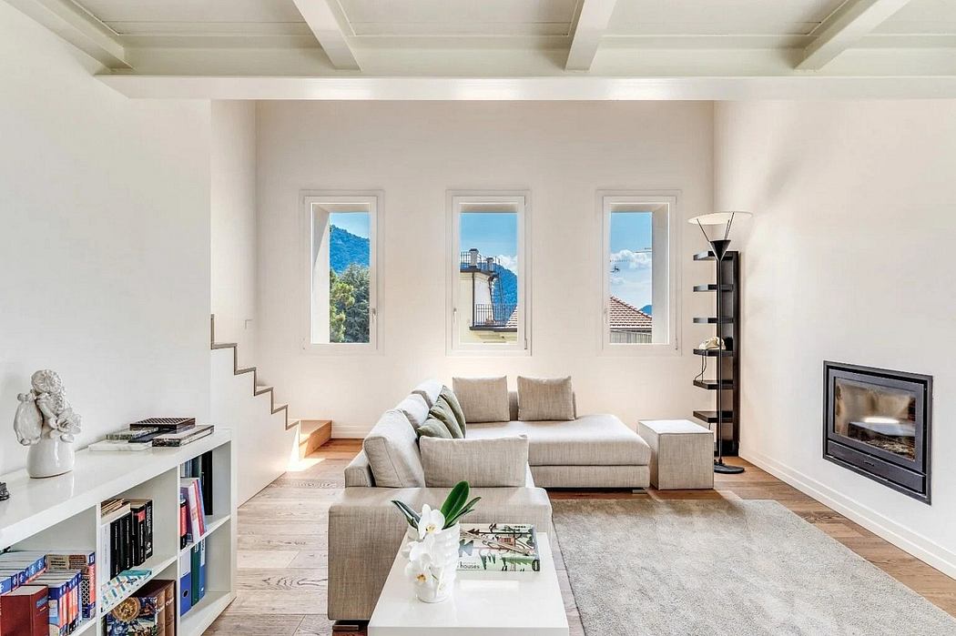 Spacious living room with large windows, neutral tones, and modern furniture.