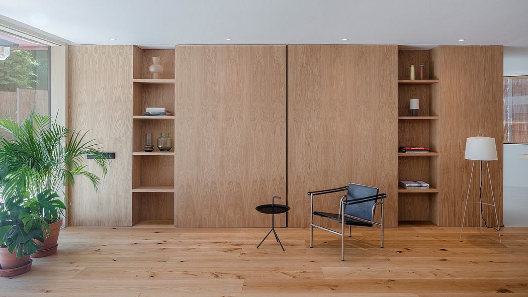 Sleek, minimalist room with wood-paneled walls, built-in shelves, and a modern armchair.