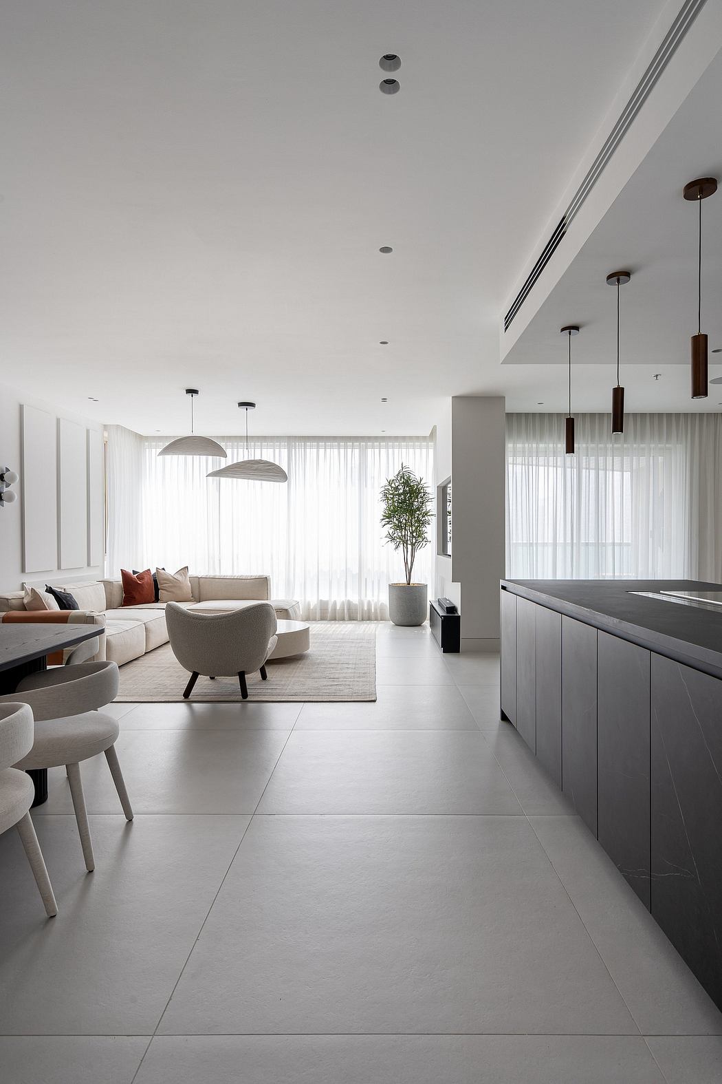 Minimalist open-concept living space with neutral palette, sleek furnishings, and recessed lighting.