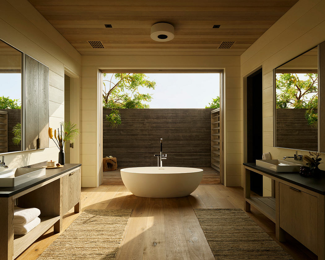 Spacious bathroom with modern freestanding bathtub, wooden accents, and lush outdoor views.