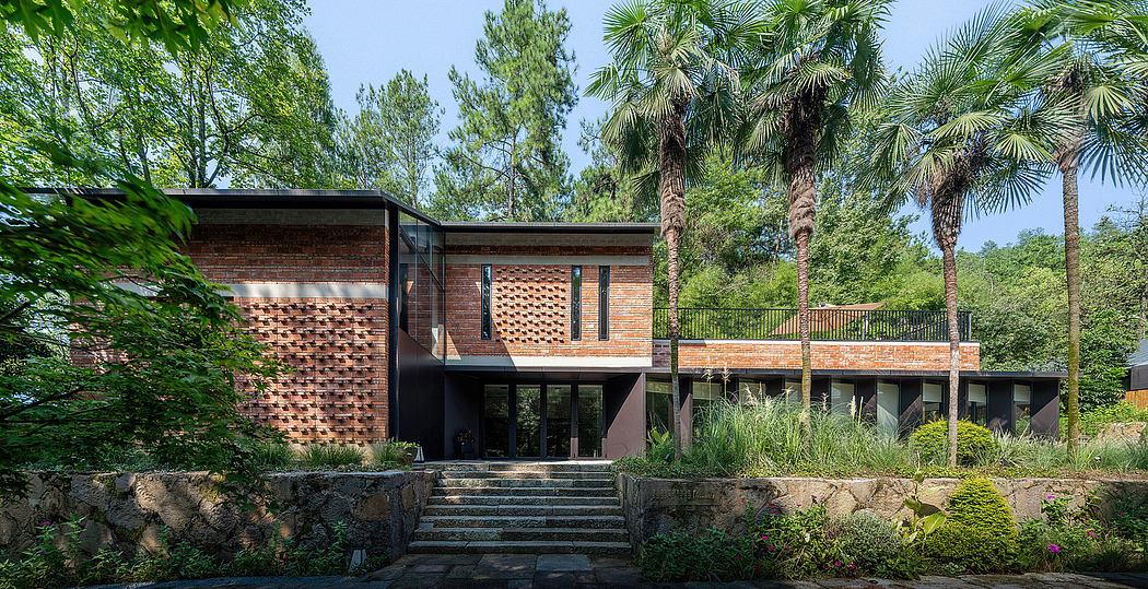 Contemporary brick and glass residence surrounded by lush greenery and palm trees.