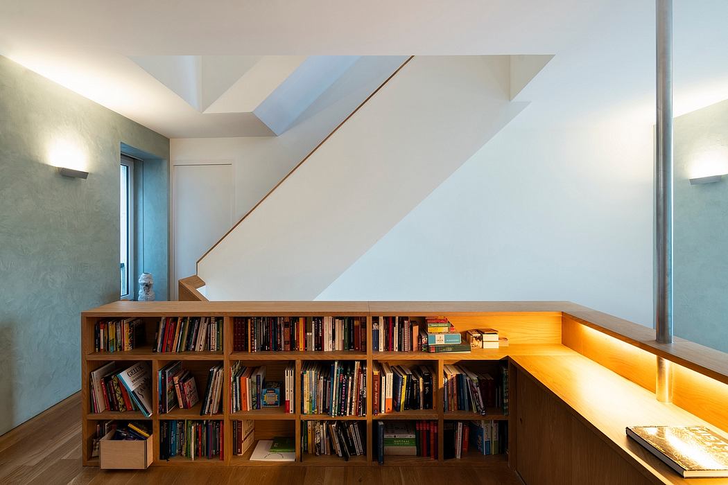Bright, modern interior with wooden bookshelf and sunlit staircase details.