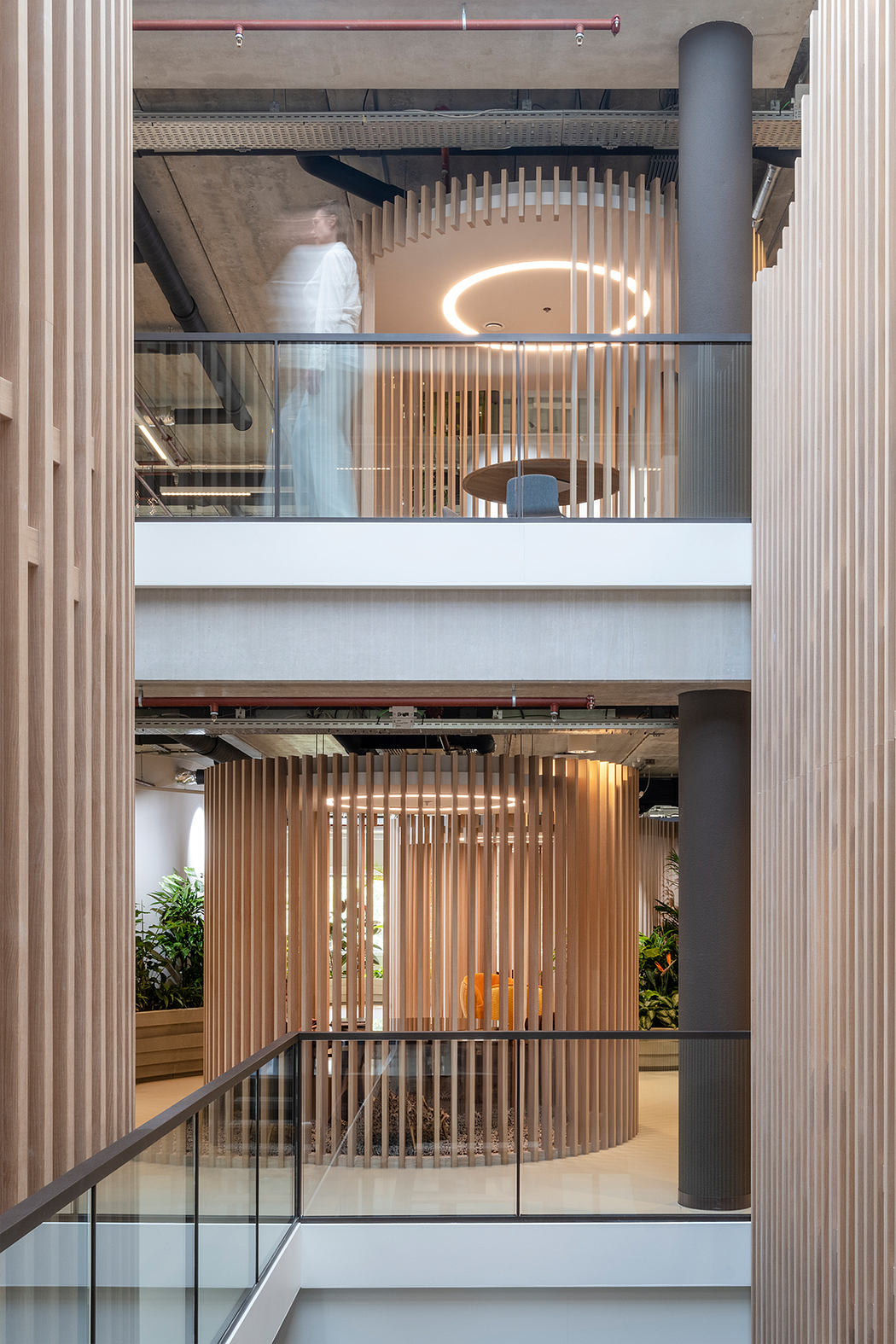 A modern, multi-level interior space with architectural wood features and lighting.