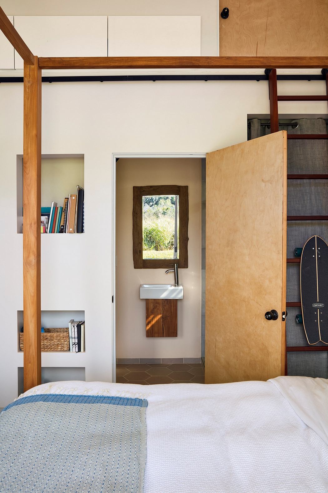 Cozy bedroom with warm wood accents, built-in storage, and a window view to the outdoors.