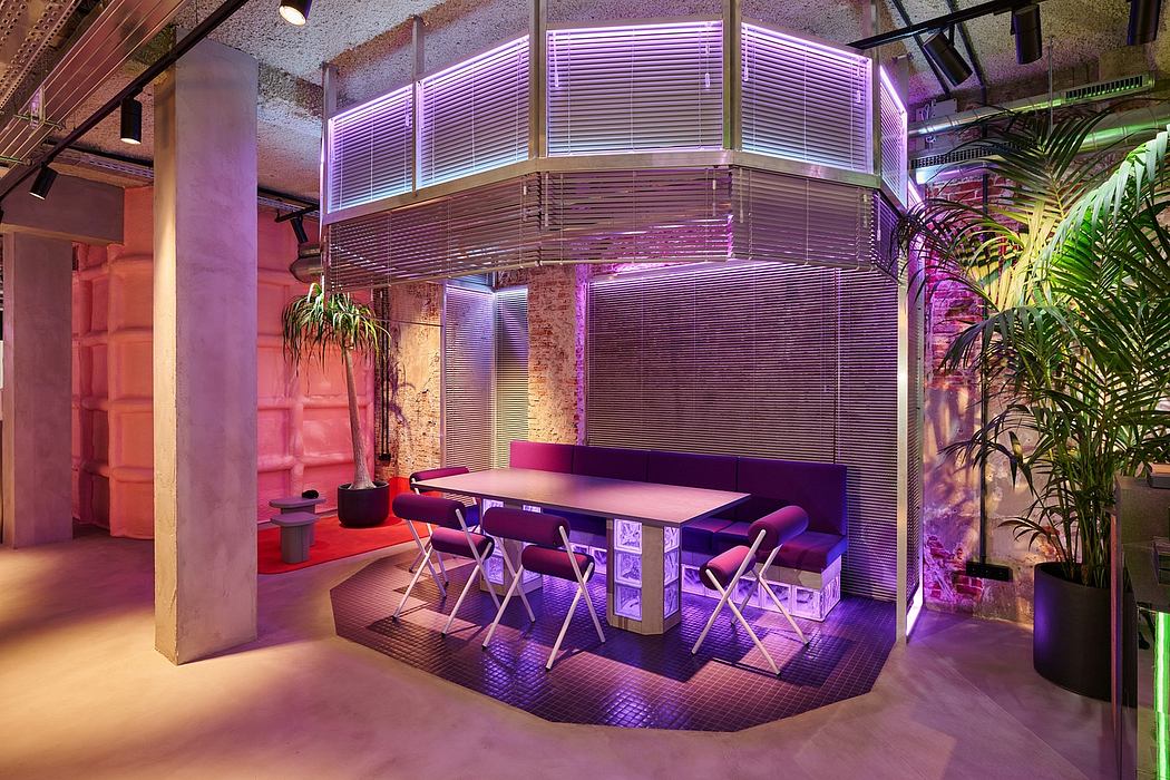 Vibrant industrial interior with neon lighting, plant accents, and modular furniture.