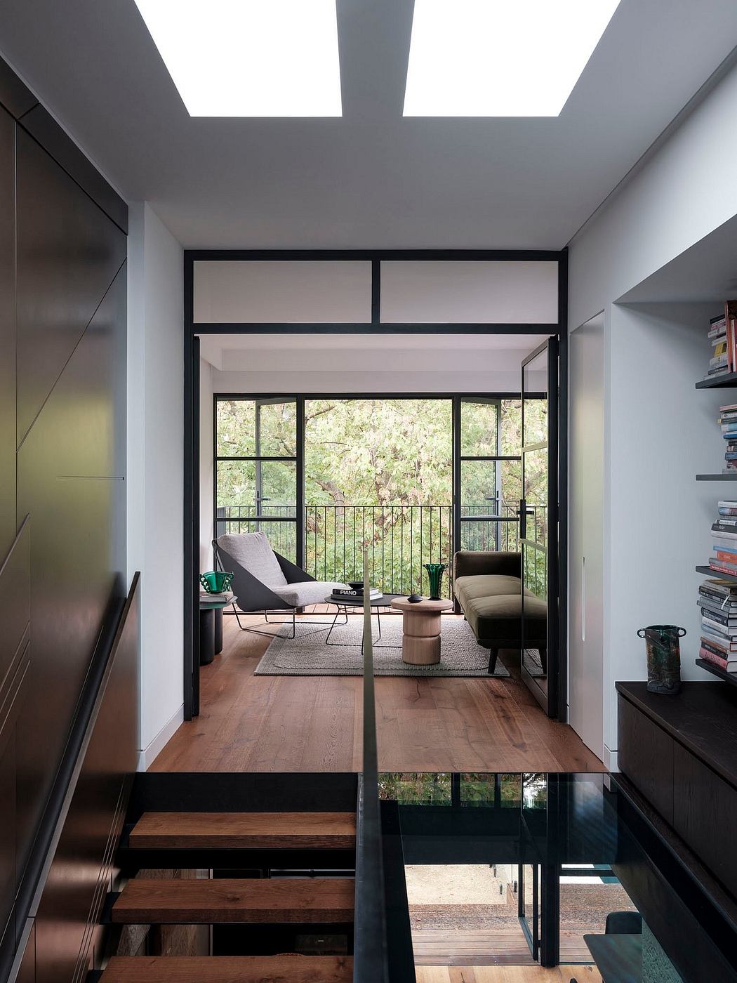 Modern interior with large windows, wood floors, and minimalist furnishings.