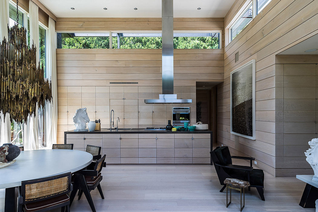 Sleek, modern kitchen with wood-paneled walls, large windows, and stylish dining area.