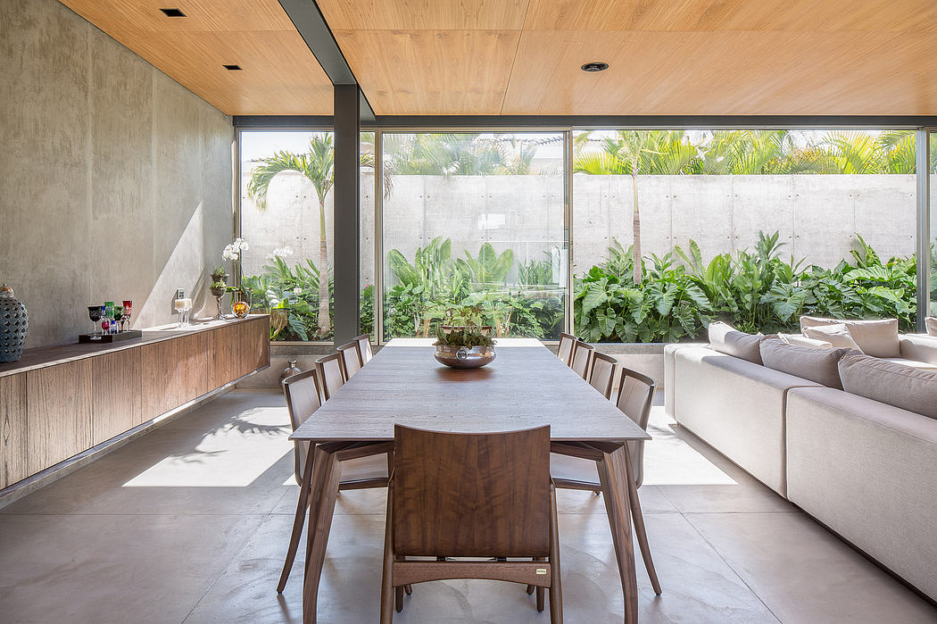 Expansive glass walls frame lush tropical foliage, complementing the modern, wooden interior.